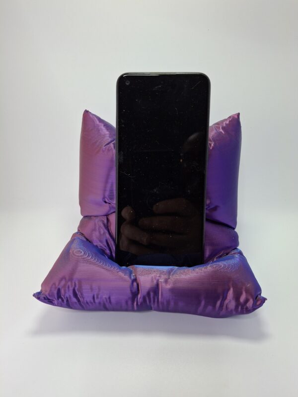Soporte para móvil impreso en 3D con diseño acolchado, compatible con todos los smartphones, disponible en múltiples colores. Ideal para uso en casa u oficina.